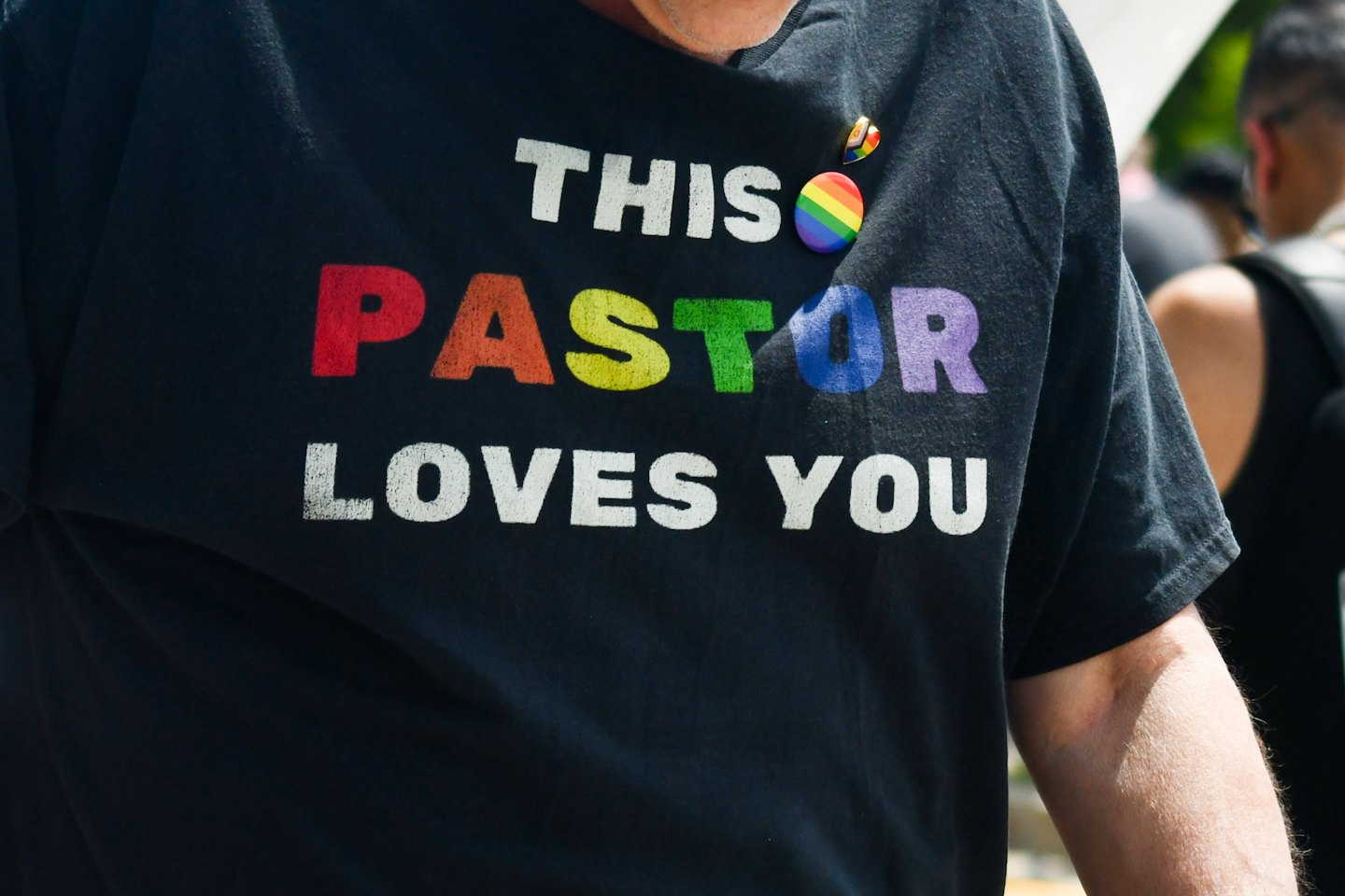 Person wearing a t-shirt with a rainbow pastor message.